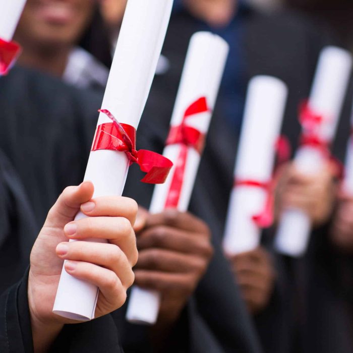 Group Of Multiracial Graduates Holding Diploma